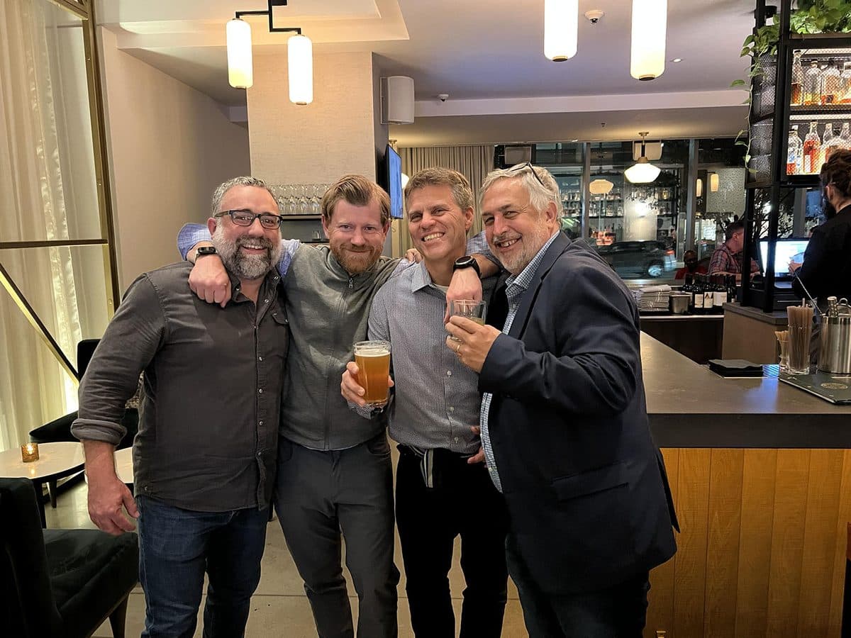 James sharing a laugh and a toast with friends at a bar