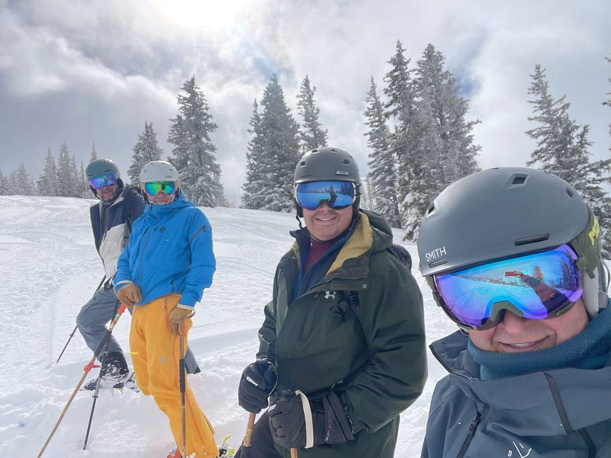 James and friends pausing together on a snowy slope during a ski trip