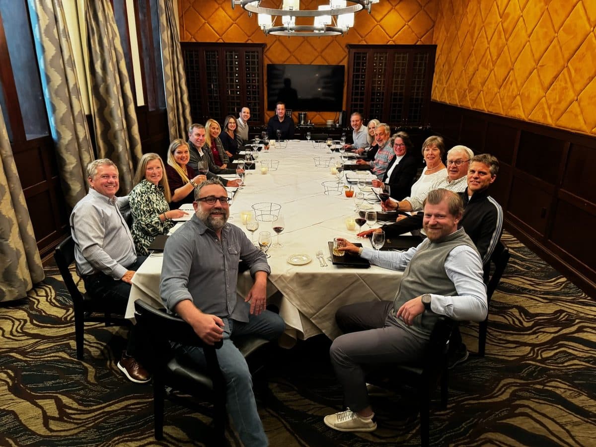 James and a large group of colleagues around the table at a team dinner