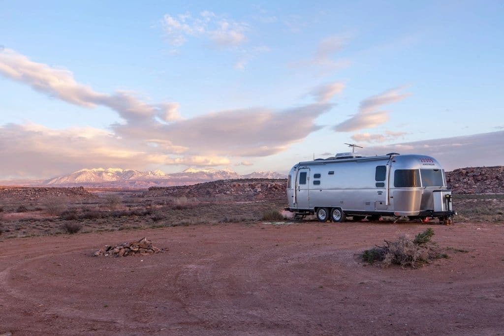 Airstream travel trailer parked in the desert at dusk