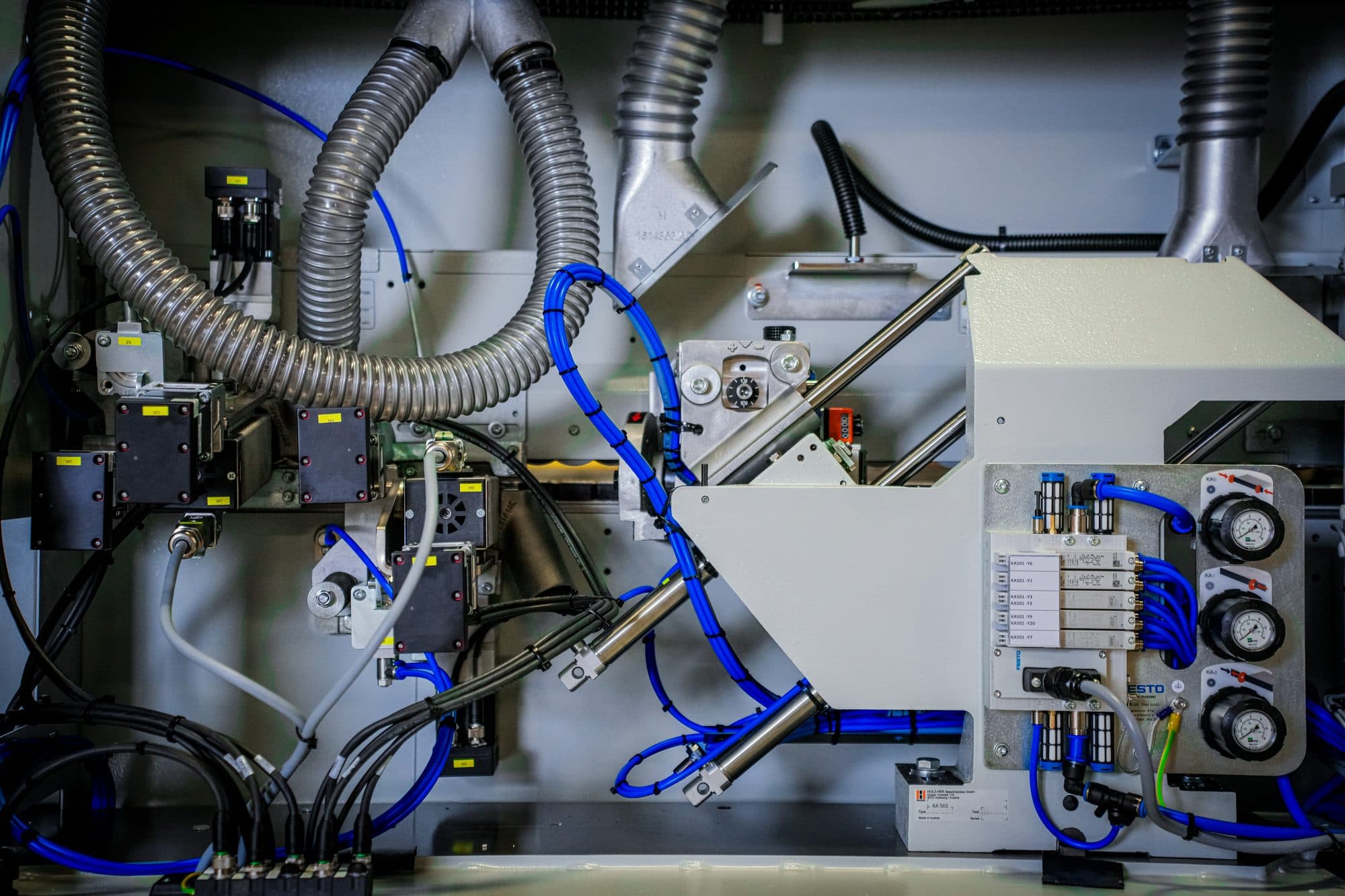 Pneumatic valves, hoses, and drive components inside a CNC machining center