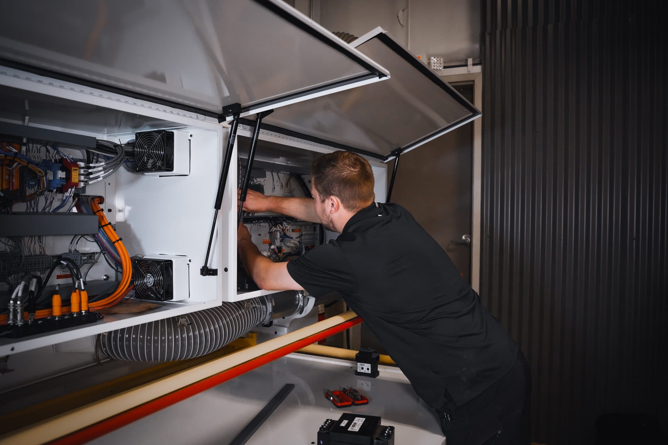 Scarlett technician servicing the electrical cabinet of a CNC machine