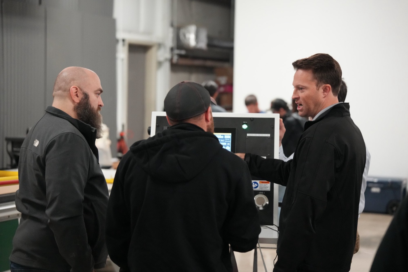 Open house visitors looking at a machine control screen in the Scarlett showroom